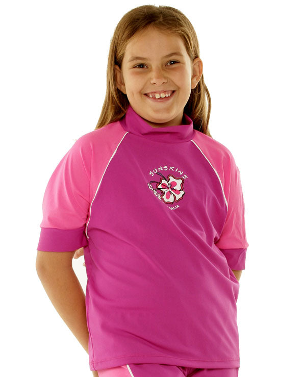girl wearing a pink rash guard with a logo