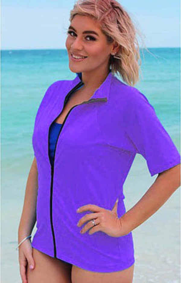 woman wearing a purple short sleeve rash guard at the beach