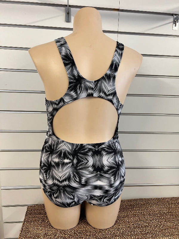 Woman wearing a black and white patterned one piece swimsuit