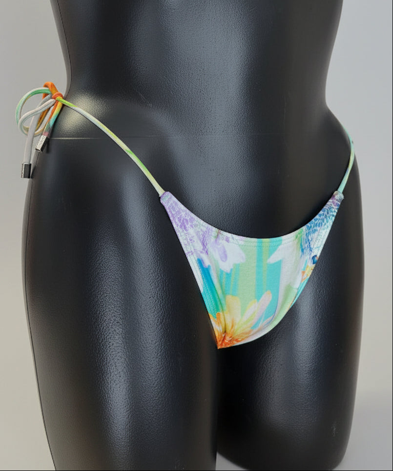Tie Side bikini has a colorful floral print with shades of blue, green, yellow, and orange, and thin side ties.