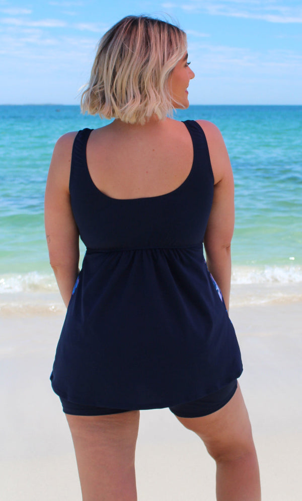 Woman wearing a navy blue swimsuit on a beach 