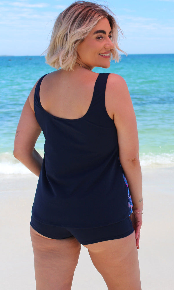 Woman wearing a navy blue swimsuit on a beach 