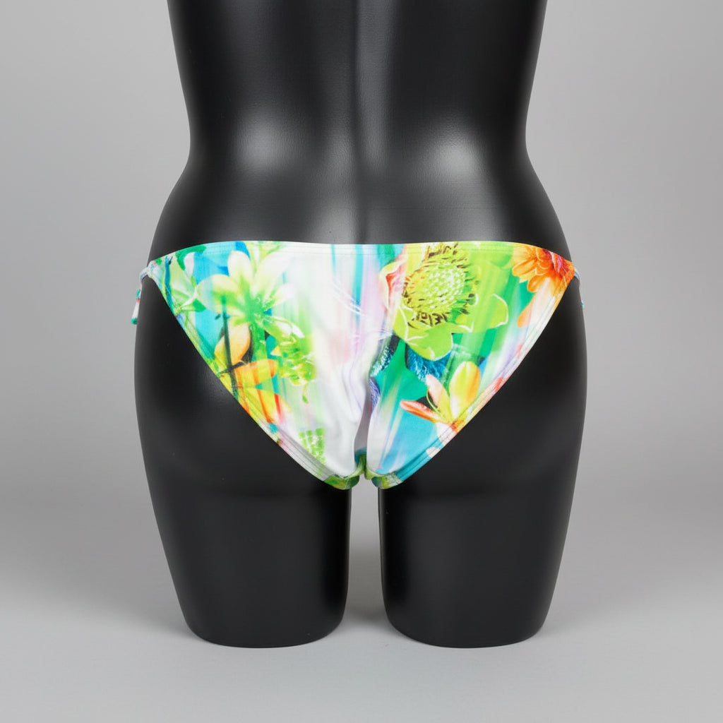 Tie Side bikini has a colorful floral print with shades of blue, green, yellow, and orange, and thin side ties.